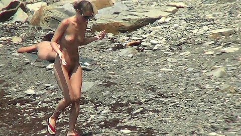 Small boobed girl walking around the beach naked while our spy camera follows her every move