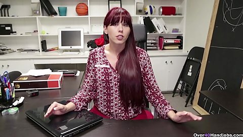 Redhead secretary milf Amber Chase looks up from behind her work desk and then tugs on dick in pov