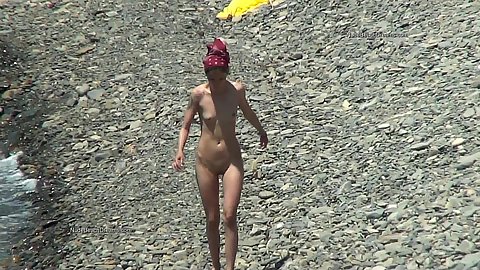 Slim small chested voyeur nudist walking along the beach without any idea that somebody is watching her from the bushes with a camera